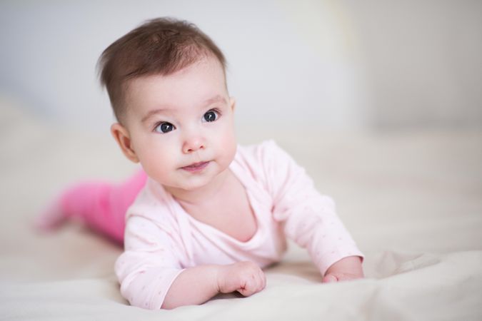 Baby in pink pant and shirt crawling