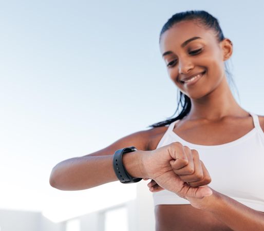Smiling woman looking at her watch during exercise