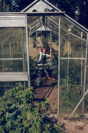 Excited kid in headphones in glasshouse