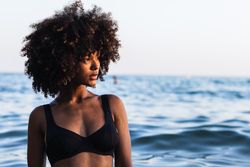 Calm Black woman in bikini in sea