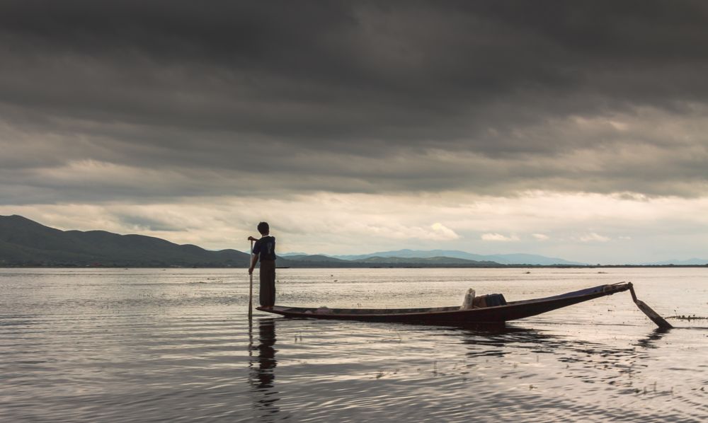 Shan, Myanmar - June, 25 2012: Anonymous fisherman standing on boat