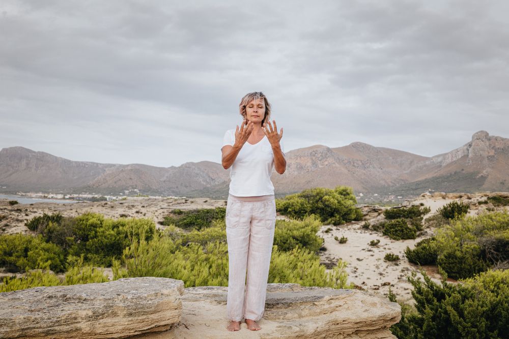 Barefoot woman meditating on stone