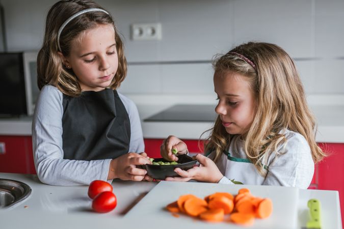 Siblings preparing vegetables for salad
