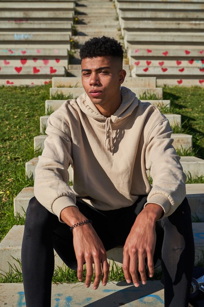 Confident Latino man sitting on stone stairway
