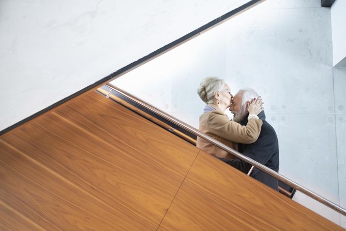 Older couple being affectionate on stairs