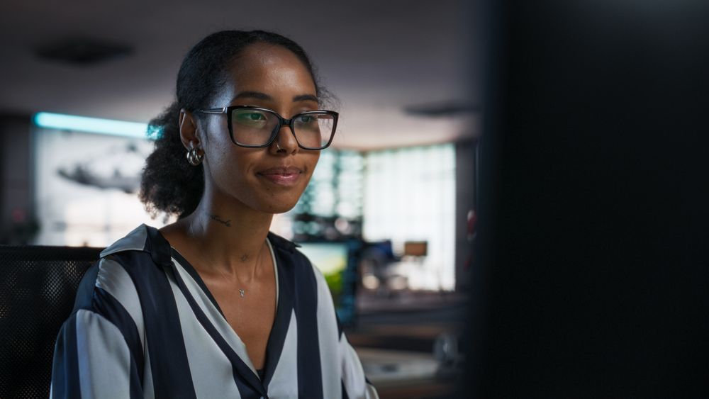 Black Woman Working on Desktop Computer in Creative Office.