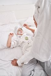 Mother applying facial mask on child during spa session