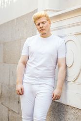 Monochrome: Portrait of a Latino man with albinism clothing against a light background.