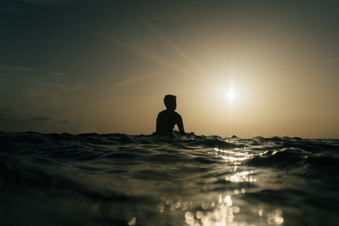 Silhouette of male surfer in water