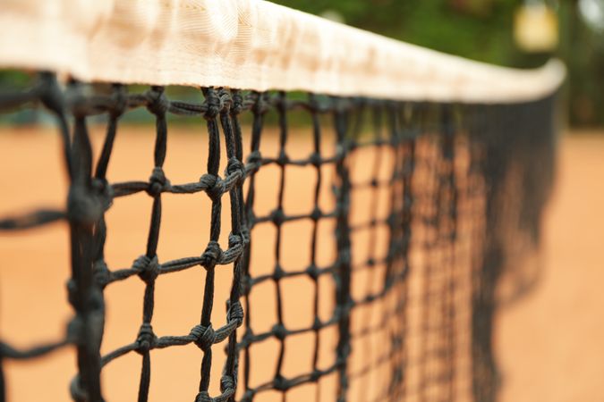 Clay tennis court with net, close up
