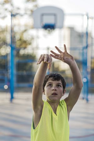 Teenage playing basketball on an outdoors court