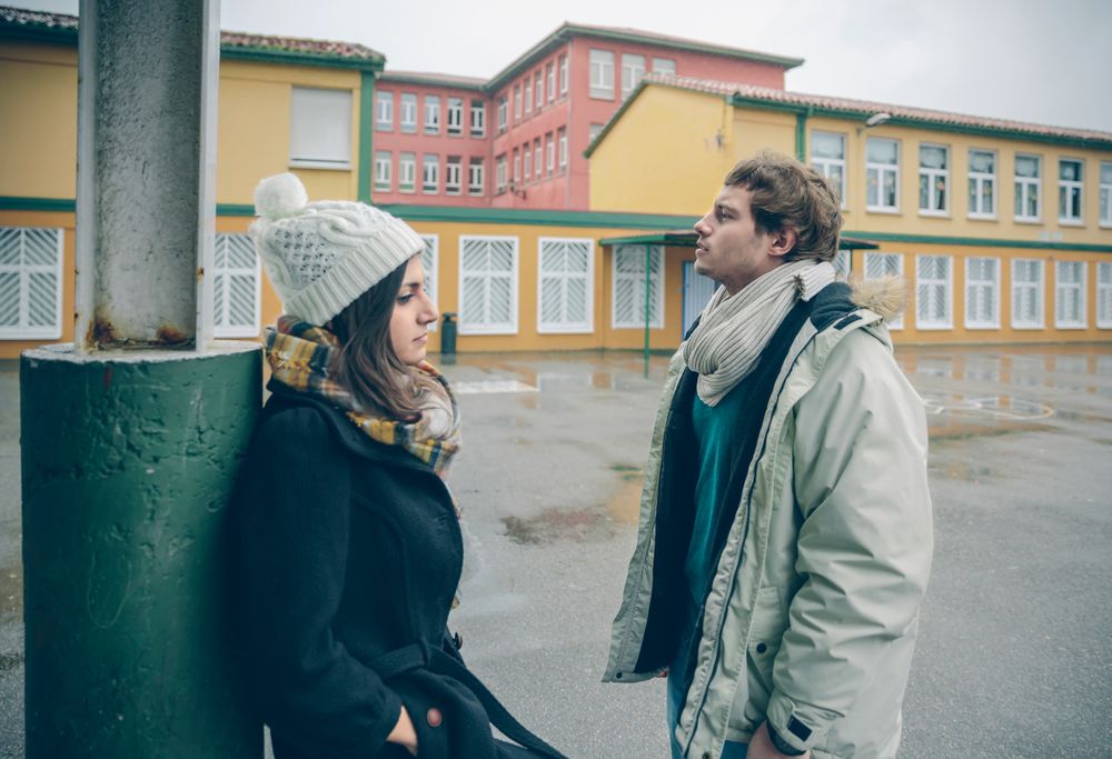 Awkward couple standing apart outside on cold day