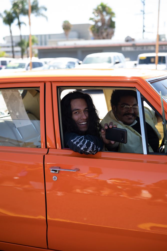 Los Angeles, CA, USA — June 7th, 2020: two men looking out of car and smiling at protest