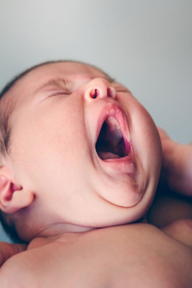 Newborn baby girl yawning