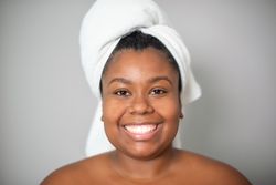 Happy Black woman with towel on head