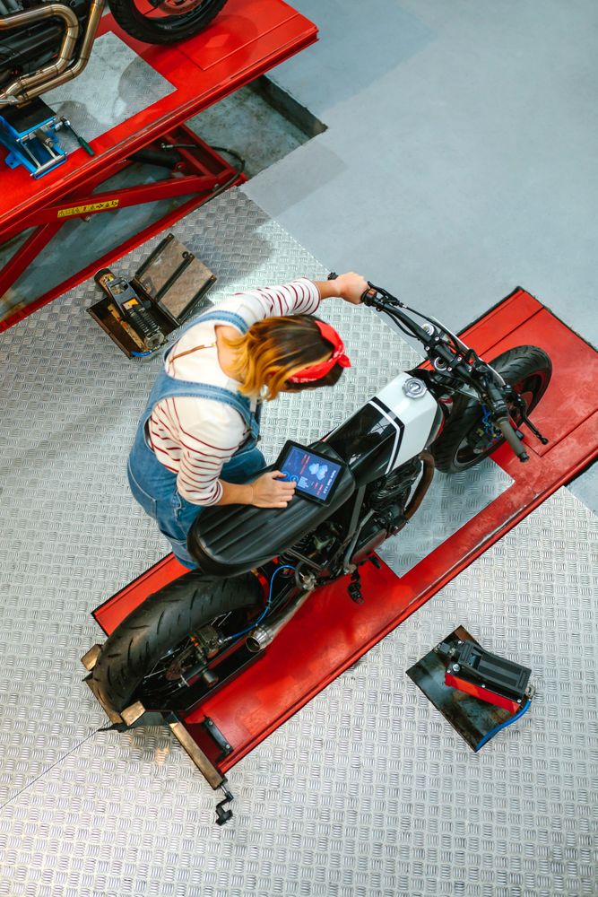 Mechanic woman using diagnosis app to review custom motorcycle
