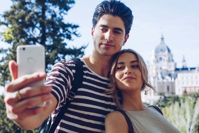 Happy young couple taking selfie in park