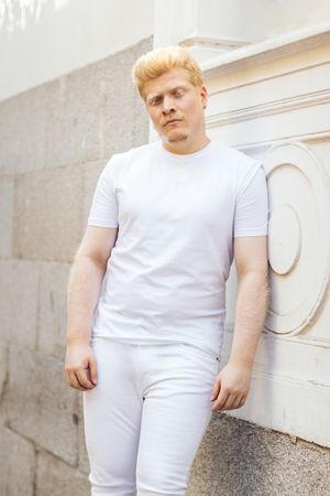 Monochrome: Portrait of a Latino man with albinism clothing against a light background.