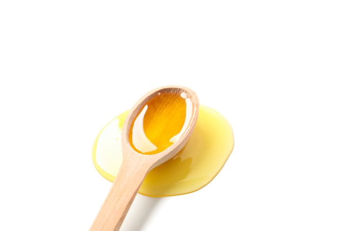 Wooden spoon with honey isolated on blank background, closeup