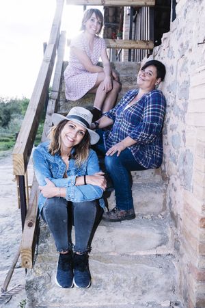 Three woman sitting on rural stairs and smiling