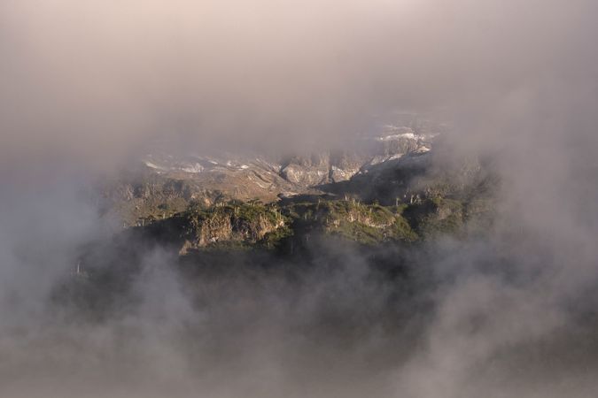 Harsh mountain snowy peak shrouded in fog