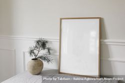Blank vertical wooden picture frame mockup next to vase 5Q2mKd