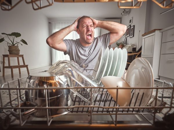 Man screaming near modern dishwasher