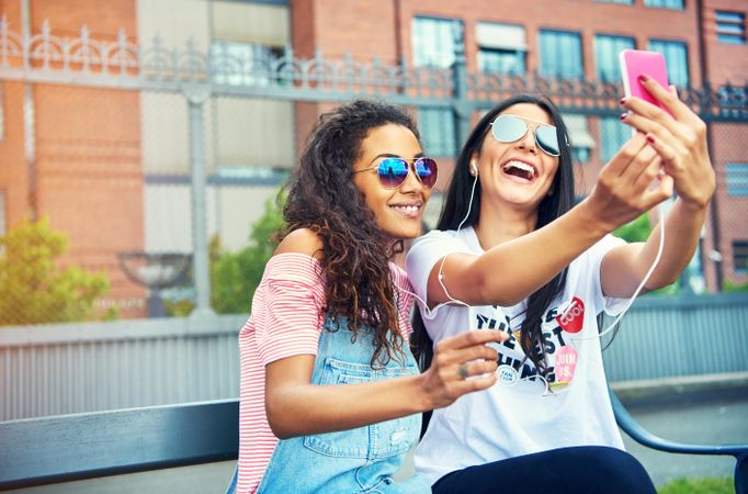 Two happy women having fun on a summer day and recording videos together on smart phone