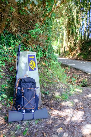 Milestone of Saint James way with backpack and hiking stick