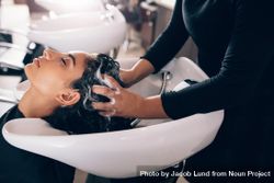 Female hairdresser using hands to massage conditioning solution to client’s hair 5Q1gN5