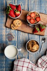Glasses near fruits and cookies on table near napkin