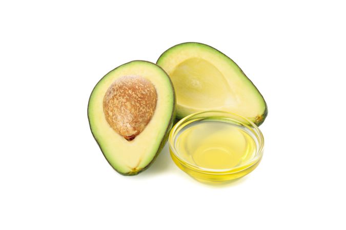 Ripe fresh avocado and oil isolated on blank background