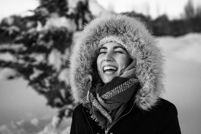 Young woman laughing on snowy background