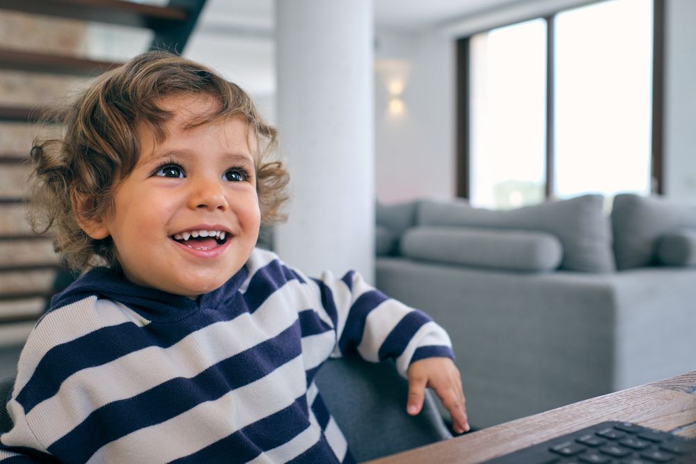 Cheerful boy sitting at table and smiling