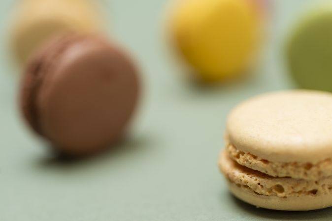 Close up of colored tasty macaroons over a green background
