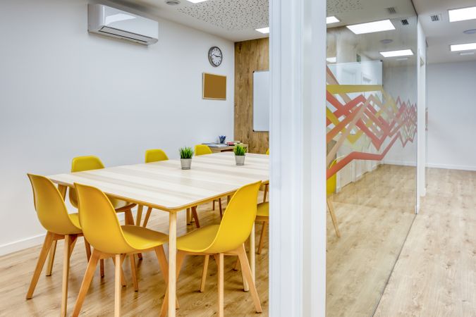 Interior of light corridor among glass walls in modern office with colorful furniture