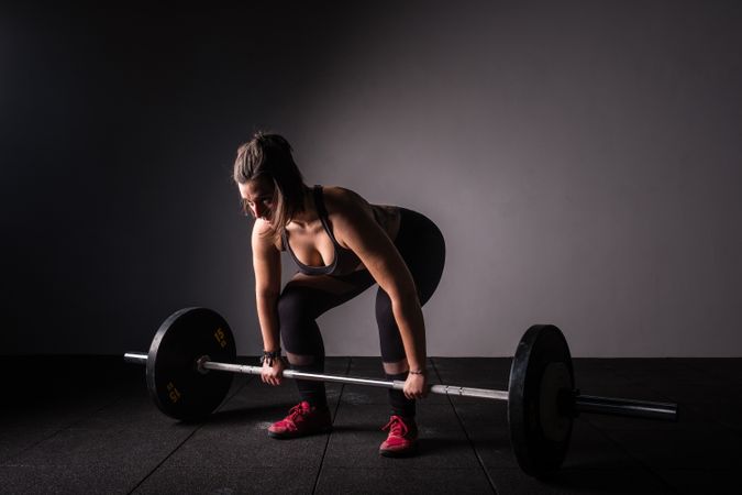 Woman lifting barbell in gym