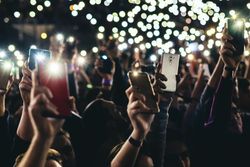 Cropped image of audience holding the phones in the air 5nKB24