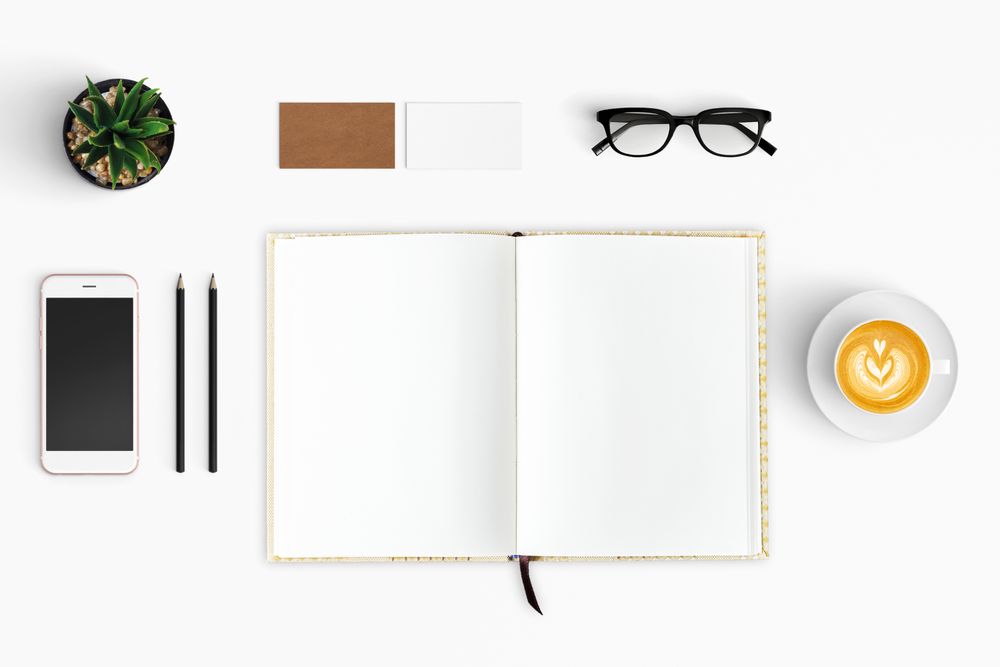 Modern workspace with coffee cup, smartphone, paper, notebook, tablet copy space
