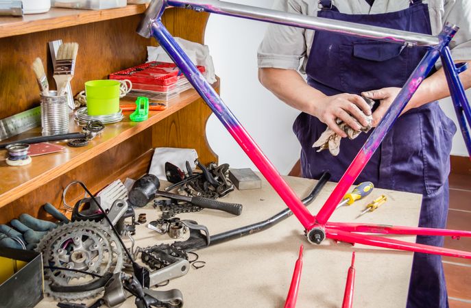 Hands of real bicycle mechanic cleaning frame bike