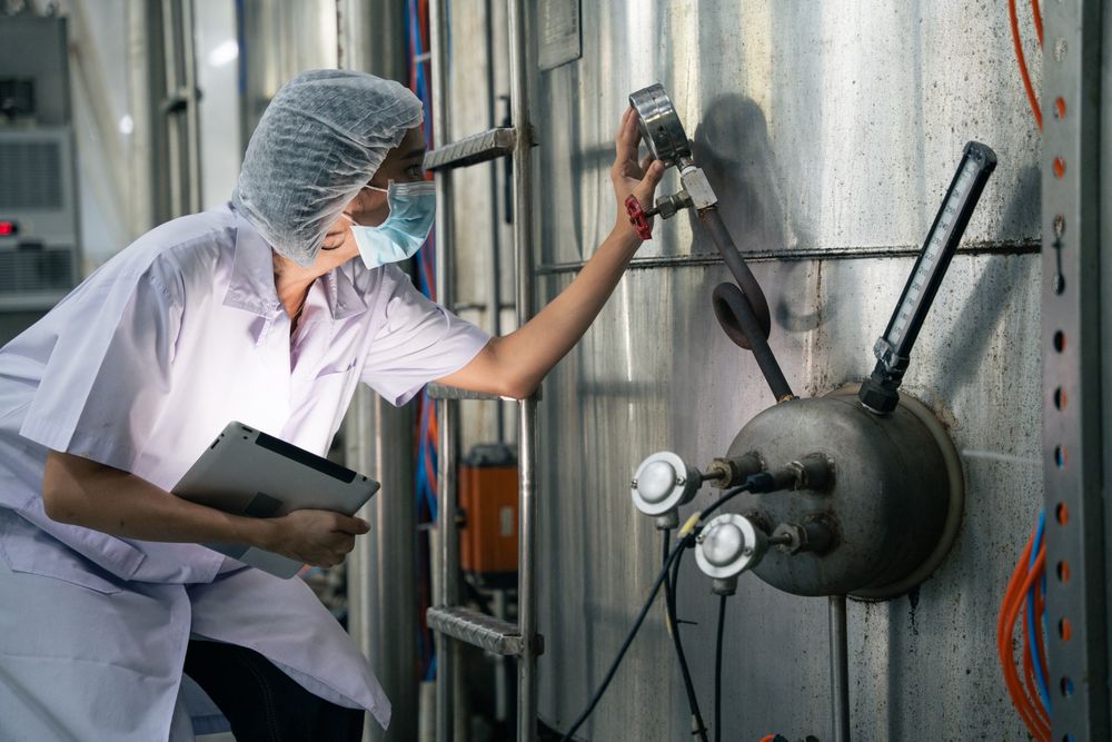 A food factory researcher inspecting canned food conveyor belt machine.