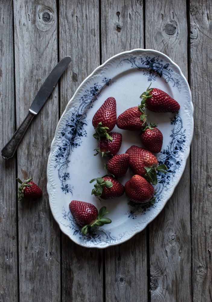 Plate with strawberries near napkin and knife