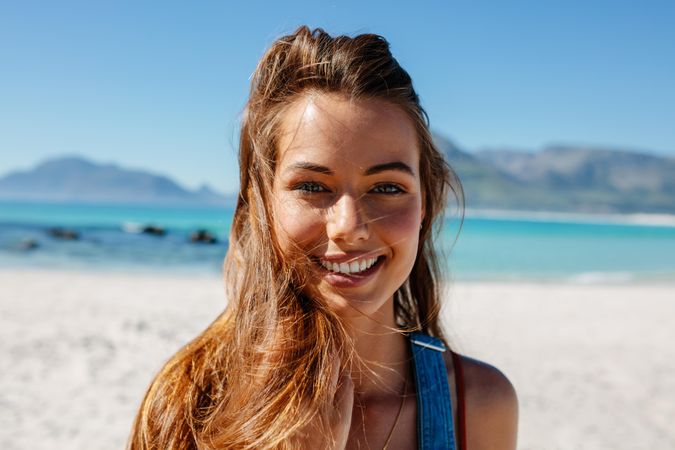 Young female relaxing at the beach and smiling on a sunny day