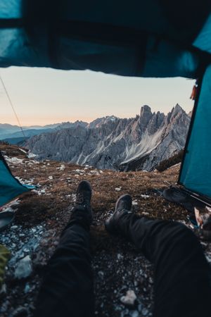 Cropped image of a person sitting in a tent in Dolomites, Italy