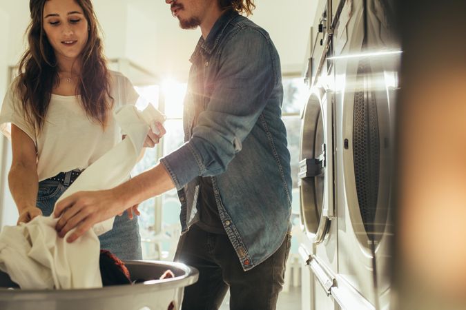 Couple doing laundry together picking clothes from a basket