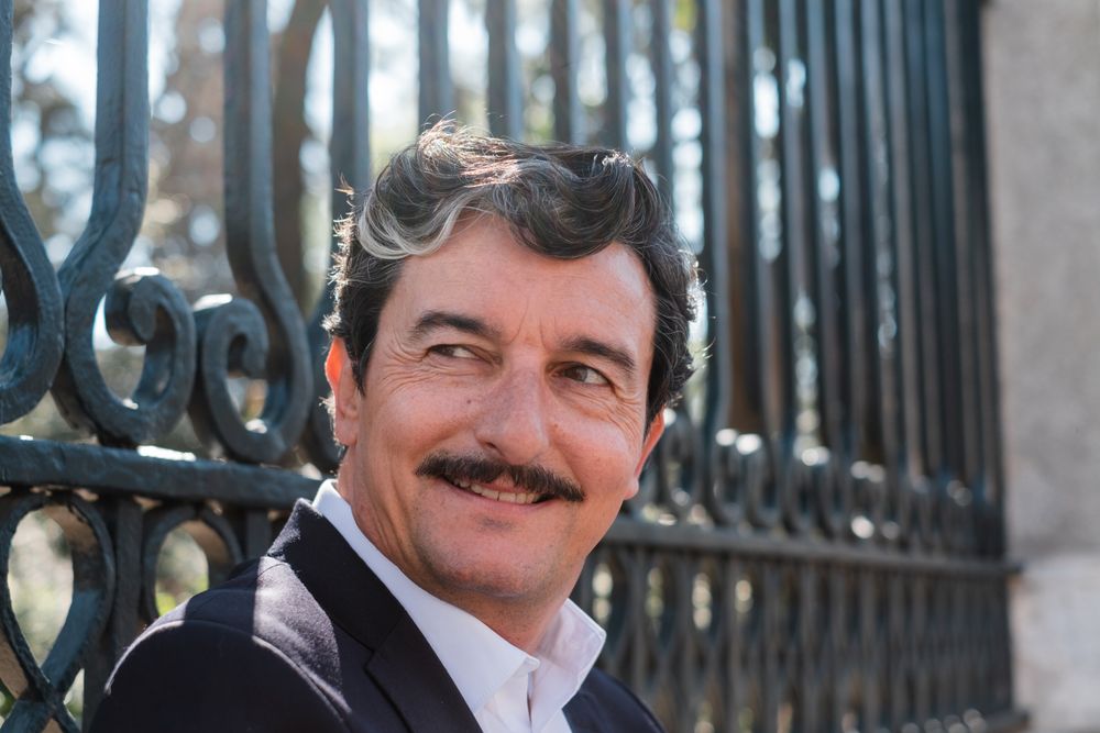 Older accomplished businessman waiting for meeting on bench outdoors