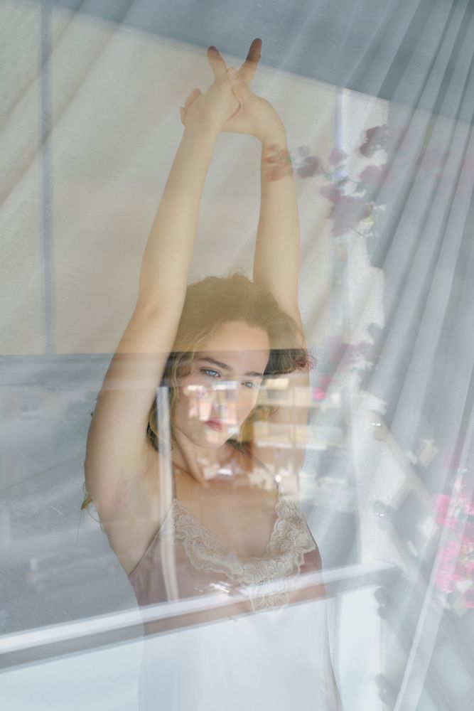 Calm young woman stretching arms in morning
