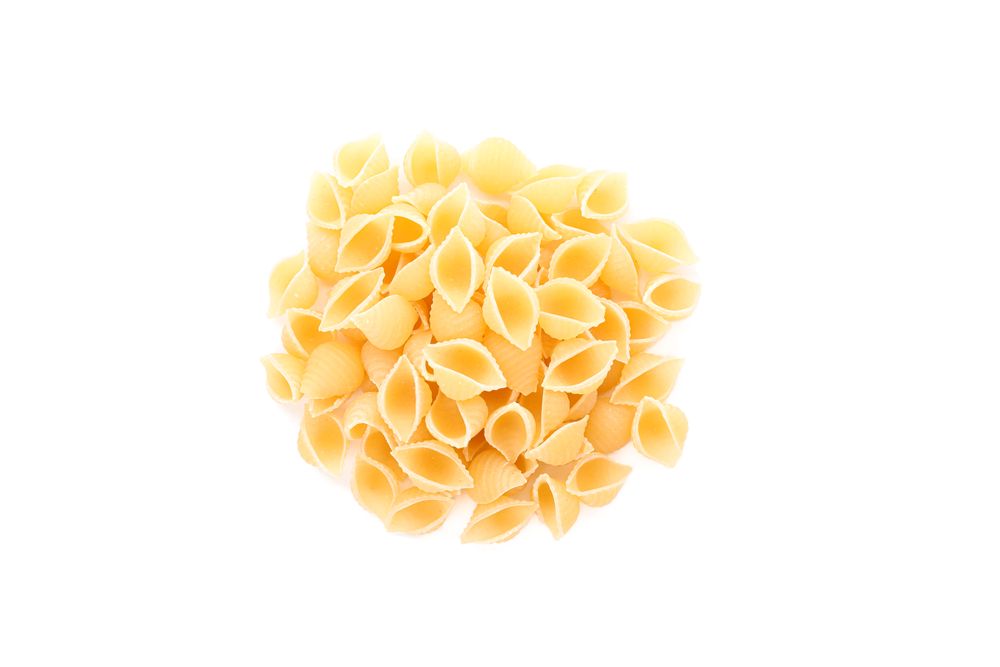 Pasta isolated on bright background, top view. Traditional shape of dry uncooked whole pasta