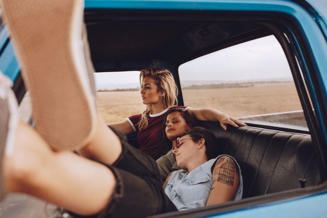 Two women sleeping in car with a friend driving