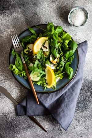 Top view of green salad with lemon slices